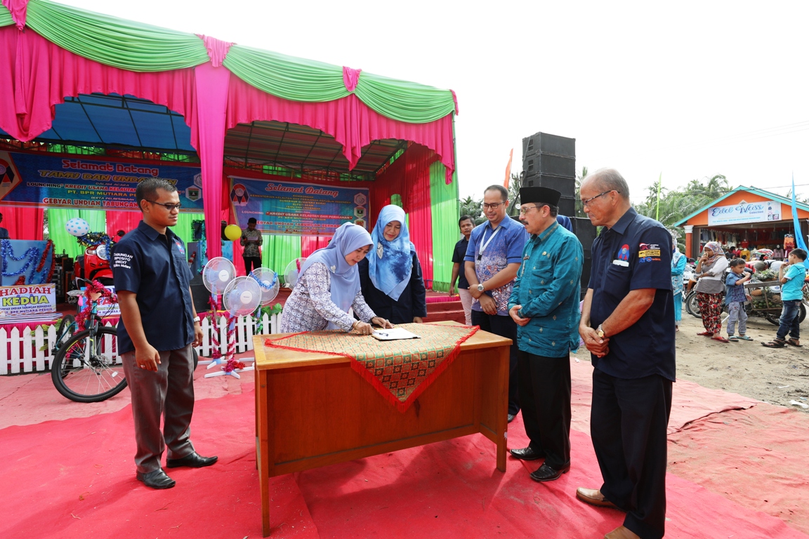 Kepala Devisi Keuangan dan Pengelolaan Resiko LPMUKP, Kartika Rini, saat menandatangani akad kredit dengan Dirut PT. BPR Mutiara Pesisir Sri Mulyani, didampingi Asisten Ekonomi dan Pembangunan Isman Imran. Foto : Istimewa
