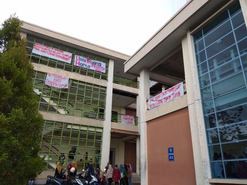 Mahasiswa Fakultas Ekonomi Universitas Bung Hatta, Padang Sumatera Barat memasang spanduk di sejumlah gedung kampus saat peringatan Hardiknas 2018