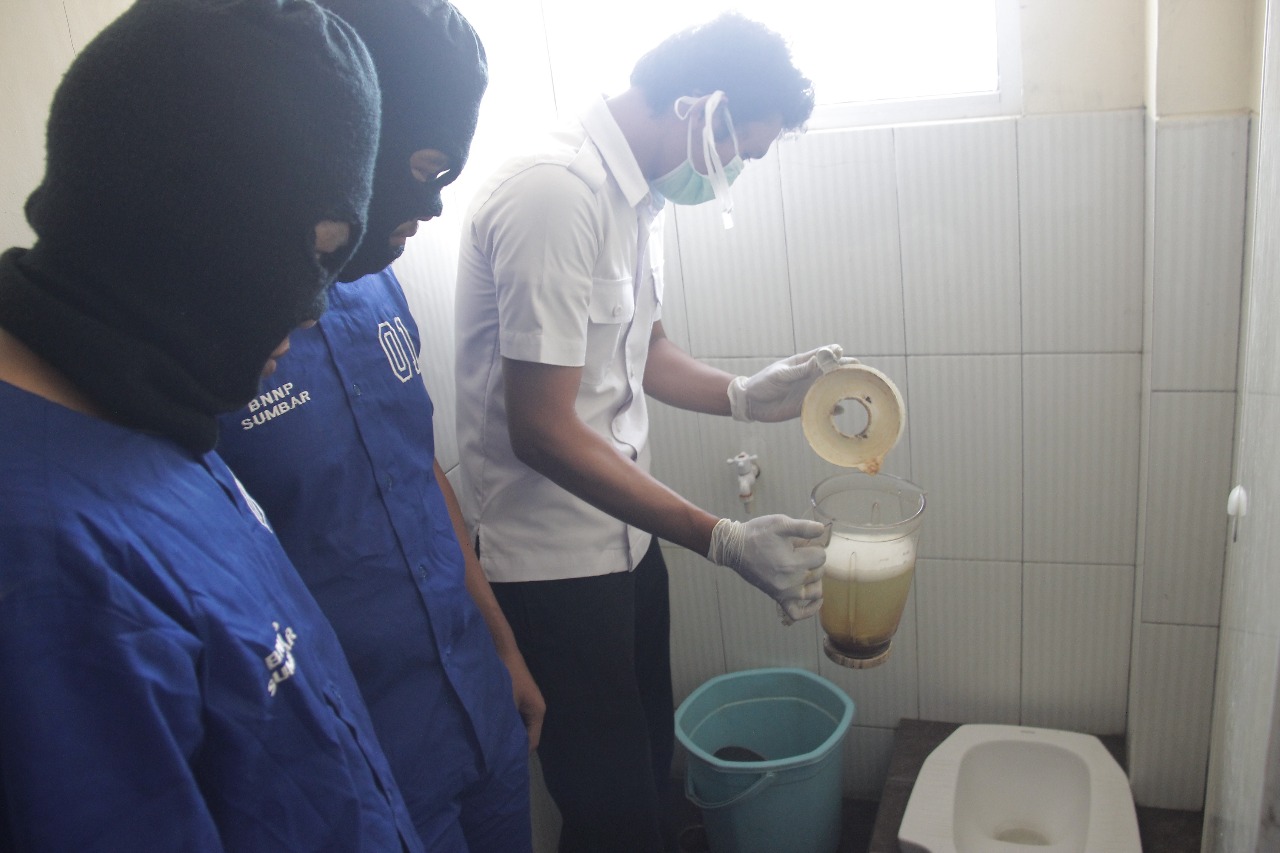 Petugas BNNP Sumatera Barat memunashkan barang bukti dengan membuangnya kedalam lubang kloset, Senin 7 Mei 2018. Foto : Istimewa