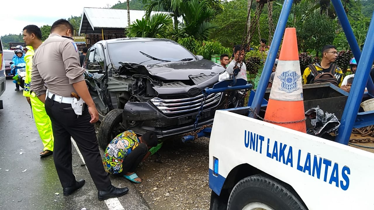 Petugas kepolisian saat mengevakuasi kedua unit minibus yang mengalami kecelakaan di kawasan Pasa Usang, Kabupaten Padang Pariaman, Minggu 27 Mei 2018. Foto : Rahma Wendra