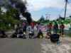 warga menghadang petugas dengan cara memblokir jalan.