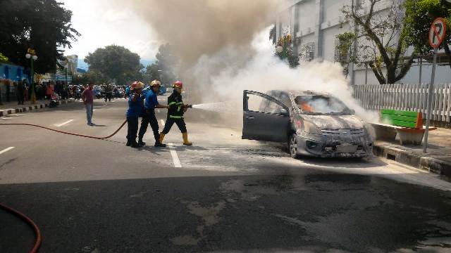 Kebakaran satu unit mobil jenis Nissan Grand Livina di kawasan Simpang Kandang Pasar Baru, Kota Padang, Jumat 8 Juni 2018.