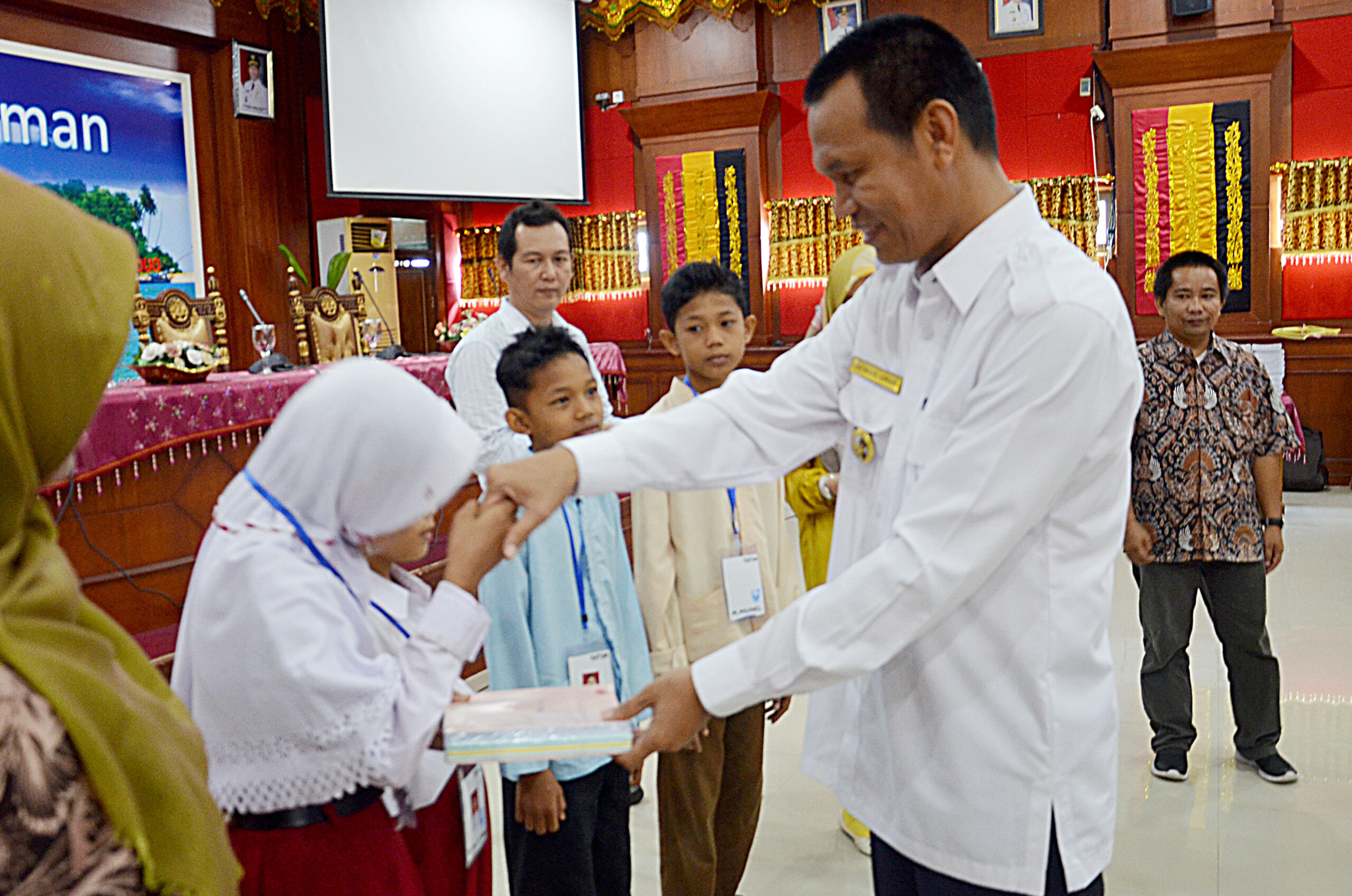 Wakil Walikota Pariaman Genius Umar menyerahkan buku tulis yang disalurkan oleh KIP kepada siswa SD Kota Pariaman dan Kabupaten Padang Pariaman di Aula Balaikota Pariaman, Rabu 1 Agustus 2018. Foto : Rizki Pratama