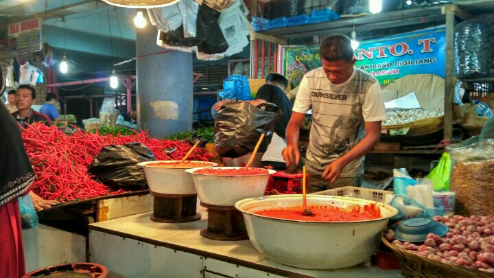 Pedagang melayani pembeli di Pasar Raya Padang. (foto: Novia Harlina)