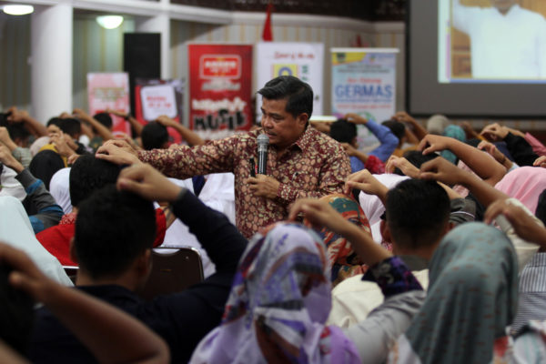 Seorang Instruktur terapi Spritual Emotional Freedom Tehknique, Benii Warlis (empat ke kanan) mencontohkan pada peserta yang mengikuti terapi rokok berhenti massal di kantor gubernuran Sumatera Barat, Padang,