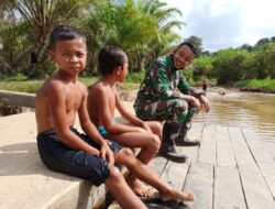 Anggota Satgas TMMD 110/ Kodim 1201 Komsos di Pinggir Sungai