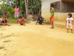 Anggota Satgas TMMD 110/ Kodim 1201 Bermain Kelereng Bersama Anak-anak Desa Tolok