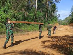 Anggota Satgas TMMD 110/ Kodim 1201 Gotong Royong Bawa Balok untuk Pembangunan Box Cluvert