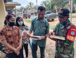 Anggota Satgas TMMD 110/Kodim 1201 Bekerja Sama Dengan Aparatur Desa Bagikan Stiker Patuhi Prokes 5M