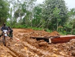 Anggota Satgas TMMD 110/Kodim 1201, Mendorong Motor di Jalan yang Berbecek