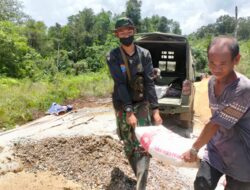 Anggota Satgas TMMD 110/Kodim 1201, Sedang Menurunkan Material Semen