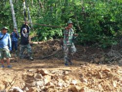 Pemasangan Papan Oleh Anggota Satgas TMMD di Jalan Yang Berlumpur Guna Kendaraan Dinas Bisa Lewat