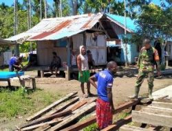 Babinsa Koramil Pantai Timur Bantu Warga Angkut Material Kayu