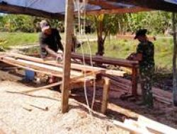 Danramil 1712-02/Pantai Timur Bantu Warga Potong Kayu dan Bersihkan Halaman Gereja