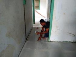Anggota satgas TMMD hampir selesai kan pembangunan Puskesmas pembantu dengan pemasangan Nat pustu keramik
