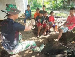 Anggota satgas TMMD bercengkrama dan bercerita bersama