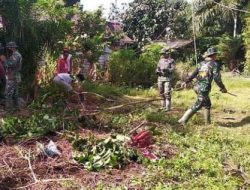 Anggota satgas TMMD kerja bakti bersama masyarakat desa dalam pembersihan lingkungan