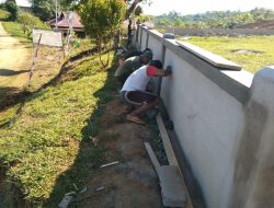 Kerjasama Anggota Satgas TMMD dan Warga Plaster Pagar Gereja Santo Kristoforus