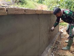 Anggota satgas TMMD perhatikan kerapian dalam pemplasteran pagar gereja.
