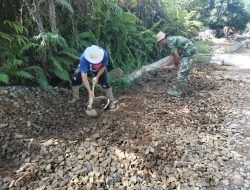 Kades Sentangau Jaya Bantu Perataan Batu Kerikil Jalan Rabat Beton Satgas TMMD Ke-111 Kodim 1202/Singkawang