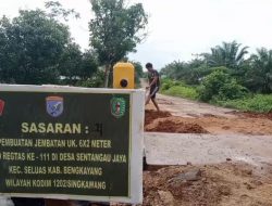 Anggota satgas TMMD dan masyarakat timbun bibir pangkal jembatan bersama masyarakat