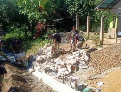 Anggota satgas TMMD kompak dalam angkut material batu kerikil