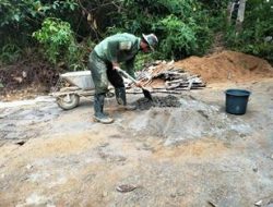 Anggota Satgas TMMD Mengaduk Semen Untuk Pemelesteran Jembatan