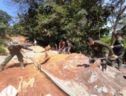 Anggota Satgas TMMD Mengaduk Semen Untuk Jalan Rabat Beton