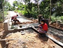 Anggota Satgas TMMD dan warga berjibaku dalam pemplasteran jembatan