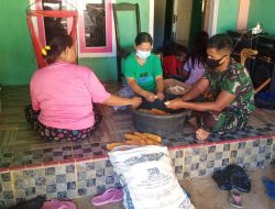 Anggota satgas TMMD bantu masyarakat desa mengupas jagung hasil kebun.