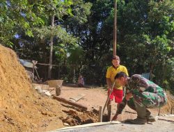 Anggota Satgas Membantu Warga Perbaiki Saluran Air