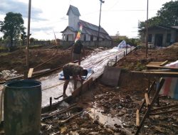 Anggota Satgas TMMD Membuka Papan Mal Jalan Rabat Beton Pustu