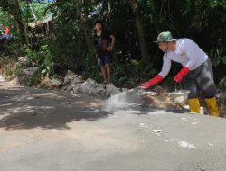 Anggota Satgas Menaburkan Semen Untuk Mempercepat Proses Pengeringan