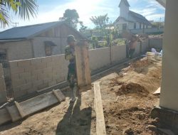 Anggota Satgas TMMD Mengangkut papan mal