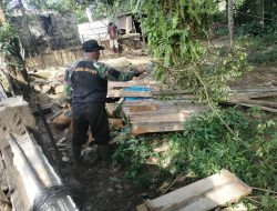 Anggota Satgas TMMD Membersihkan Area Di Sekitar Lokasi
