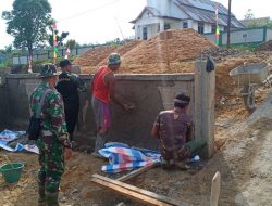 Anggota Satgas Memasang Batako Pembangunan Pagar Pustu