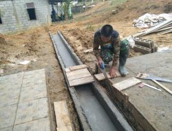 Anggota Satgas Membangun Jembatan Kecil di Depan Pustu