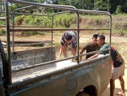 Anggota Satgas Dan Warga Turunkan Material Dari Mobil Dinas