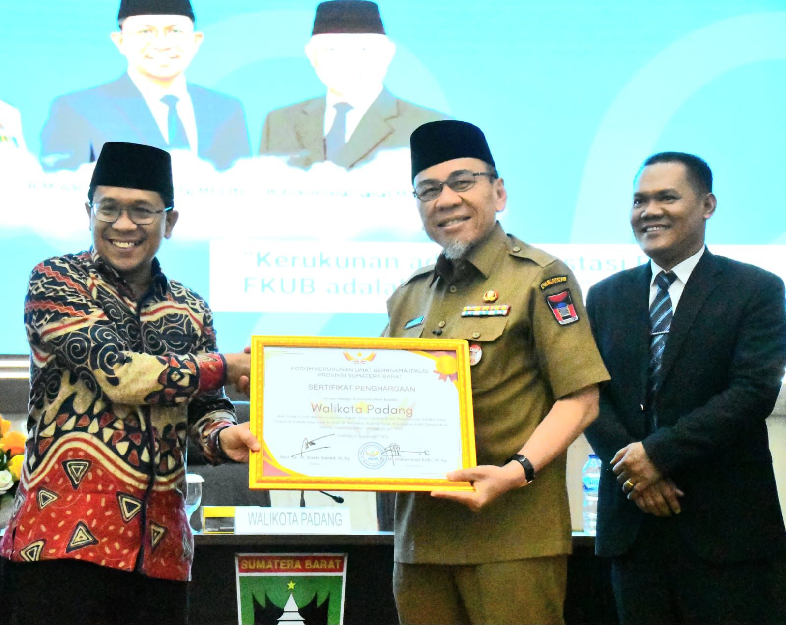 Penyerahan penghargaan kerukunan umat beragama kepada Wakil Wali Kota Padang dan Ketua FKUB Kota Padang oleh Kepala Pusat Kerukunan Umat Beragama Kemenag RI dan Ketua FKUB Sumbar di Aula Gubernuran Sumbar.