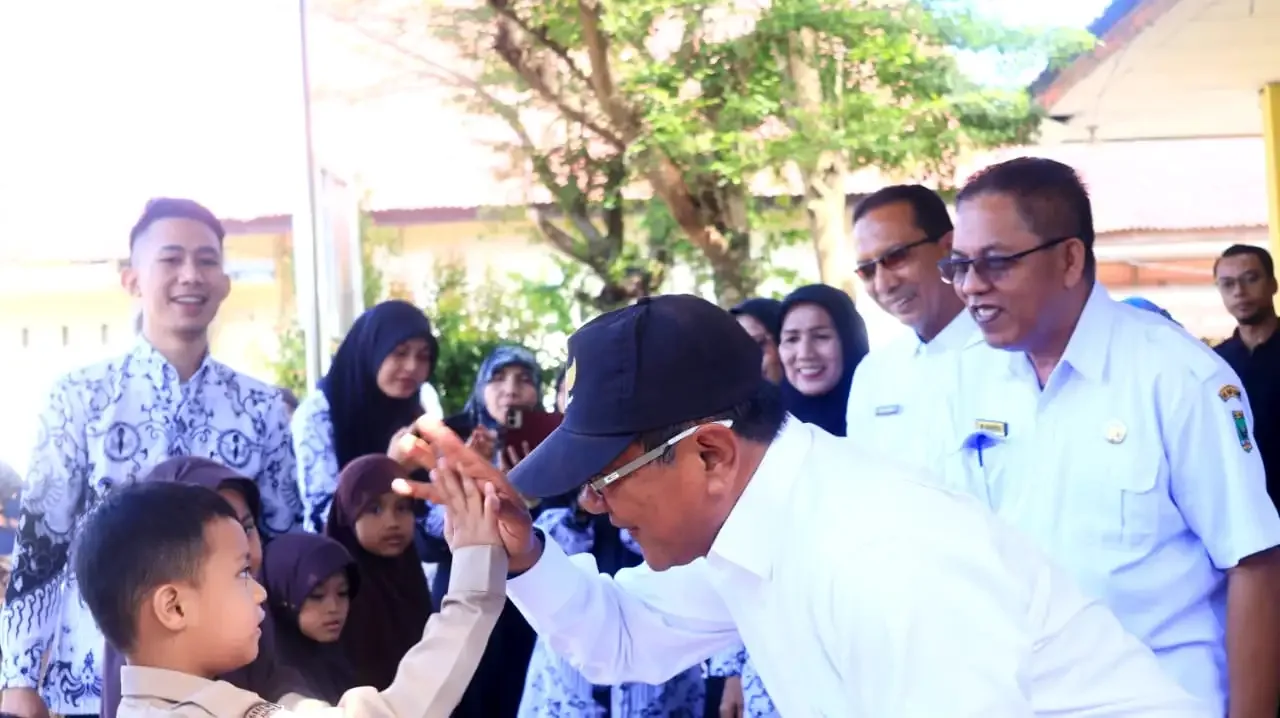 Bupati Padang Pariaman, Jhon Kenedy Azis, menyerahkan secara simbolis bantuan seragam sekolah merah putih gratis bagi siswa dan siswi Sekolah Dasar (SD) Negeri se-Kabupaten Padang Pariaman, Rabu (24/12/2025).
