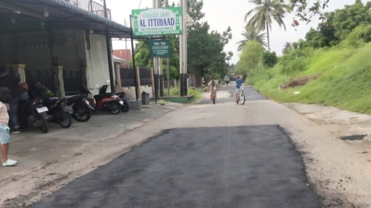 Petugas Dinas PUPR Kota Padang sedang melakukan perbaikan jalan rusak dengan metode penambalan untuk meningkatkan keselamatan